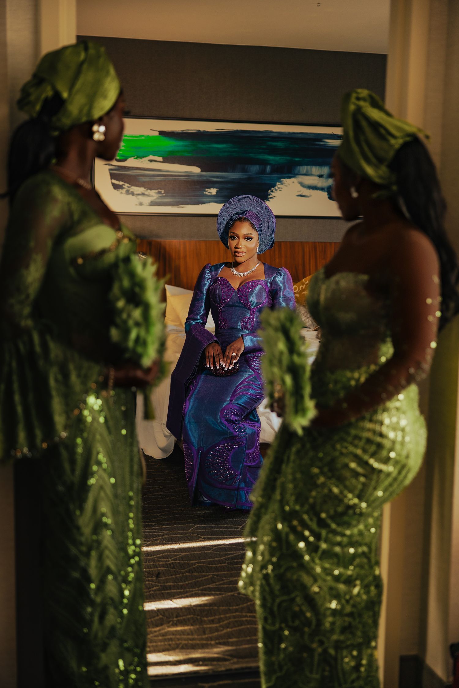 Elegant blue and green formal attire captured in a dramatic indoor setting with mirrors.