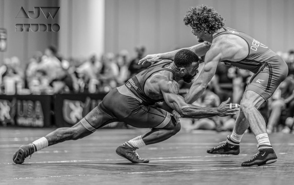 Black and white image of wrestlers locked in an intense neutral position battle.