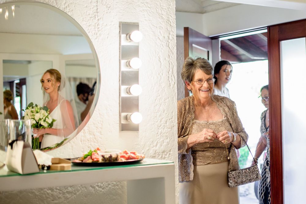 Wedding preparation scene with white curtains and mirrors in a bridal suite.