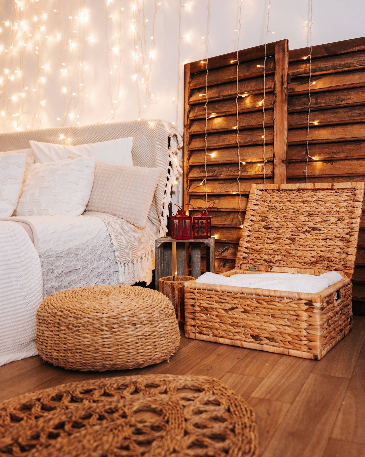Rustic wooden backdrop with woven baskets and white pillows creating a cozy seating arrangement with twinkle lights.