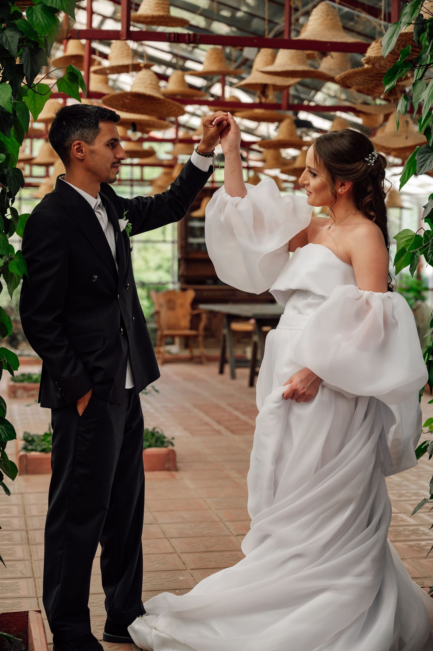 Dancing couple twirls under rustic wooden beams in an elegant venue.