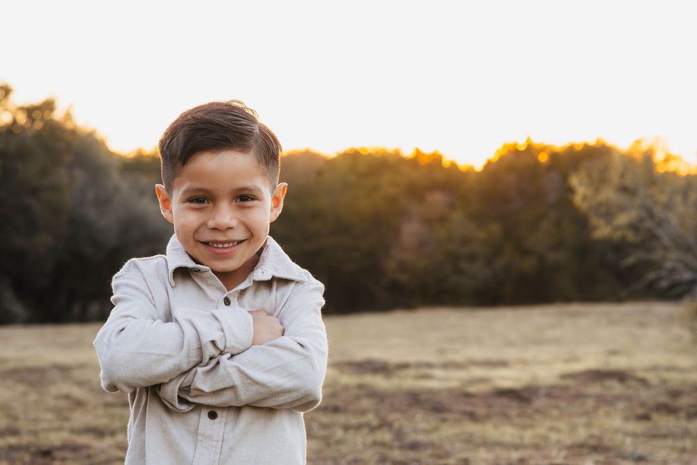 A sunset photoshoot in a golden field with warm autumn lighting and natural outdoor scenery.
