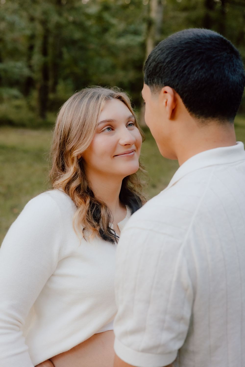 A romantic couple in white outfits shares tender moments in a series of close-up outdoor photos.