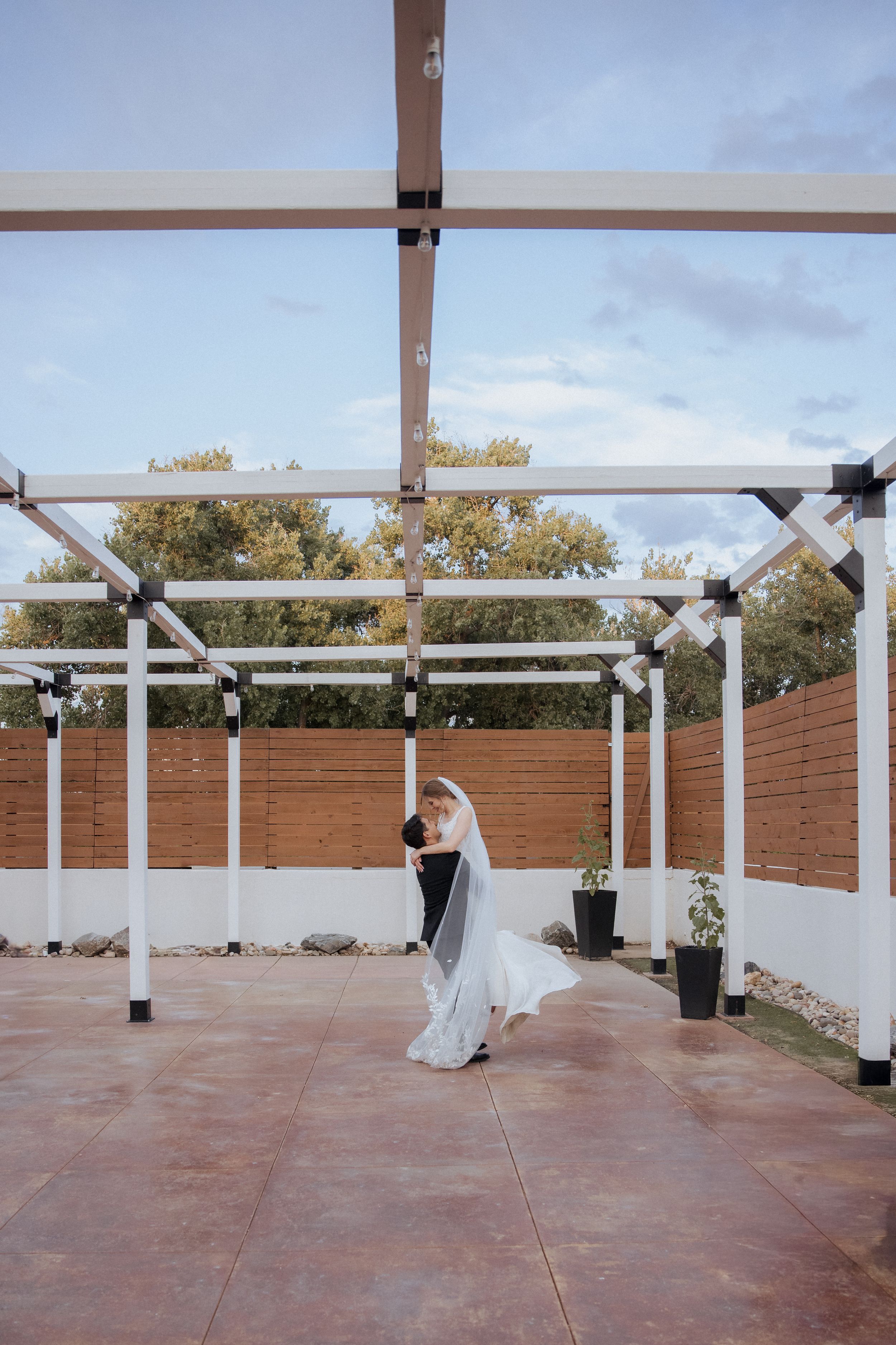 A series of photos showing a bride in a white dress walking across an outdoor terrace with wooden beams overhead.