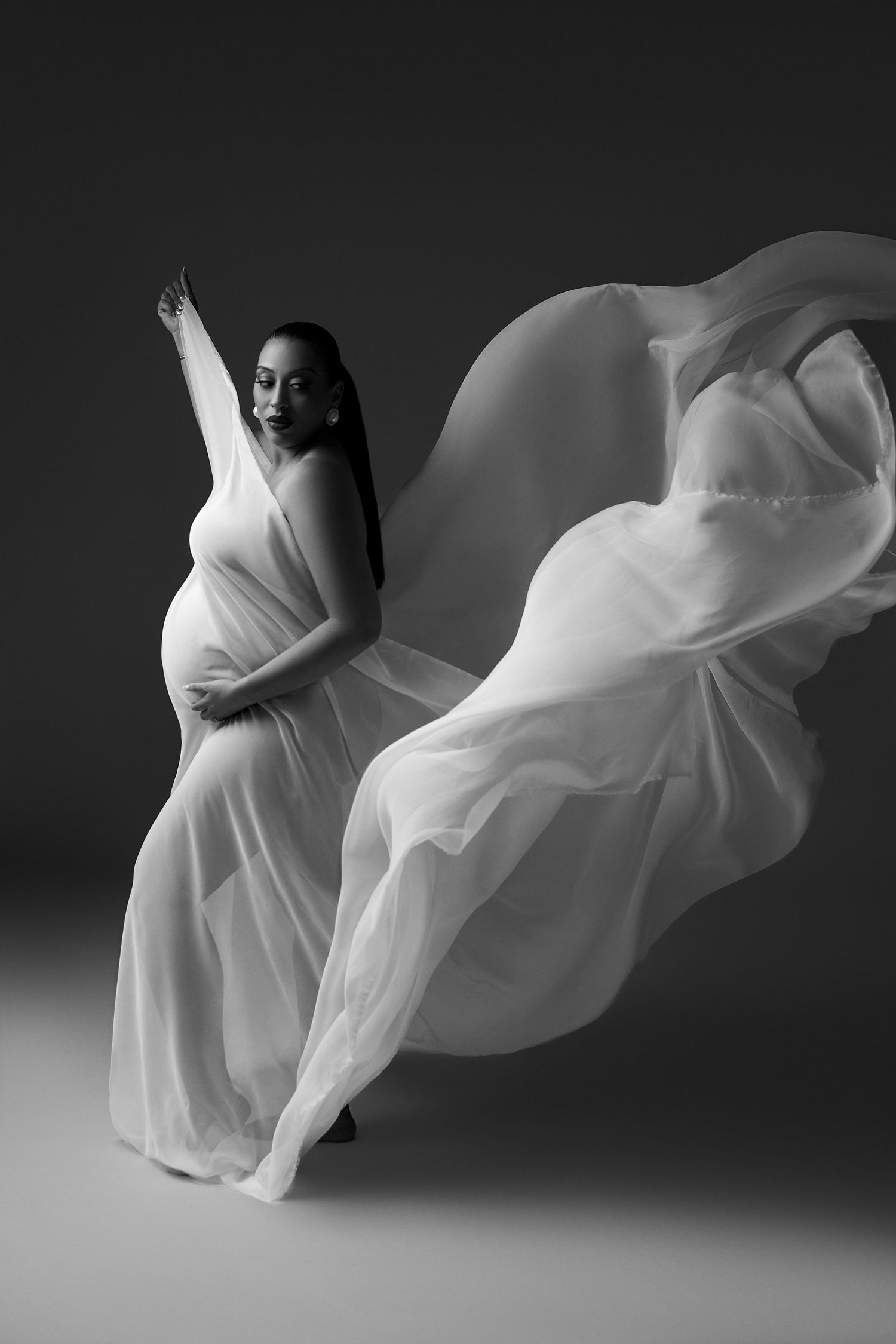 Artistic black and white photo series showing flowing white fabric in graceful motion against dark background.