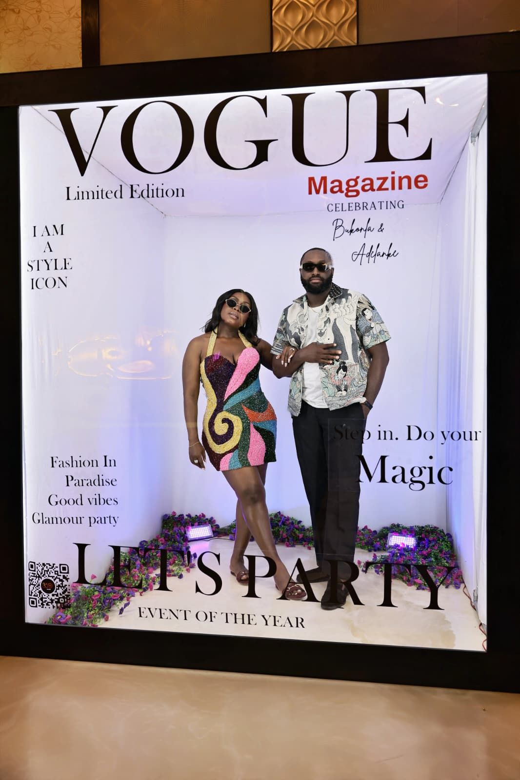 Couple posing together inside a Vogue Magazine Limited Edition Let's Party event photo booth.