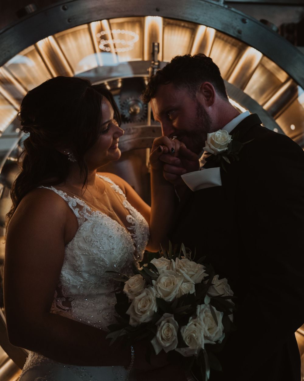 Romantic couple shares intimate moments in moody lighting during their wedding celebration.