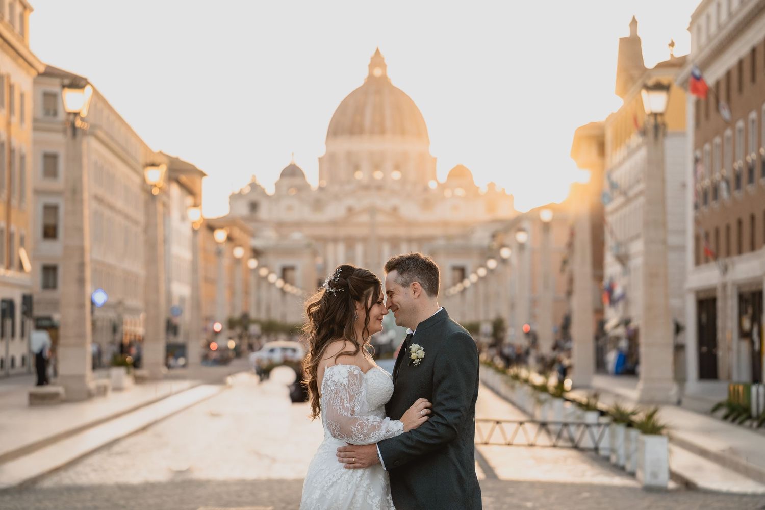 Couple sharing a romantic kiss in front of St. Peter's Basilica in Rome at golden hour on their wedding day.