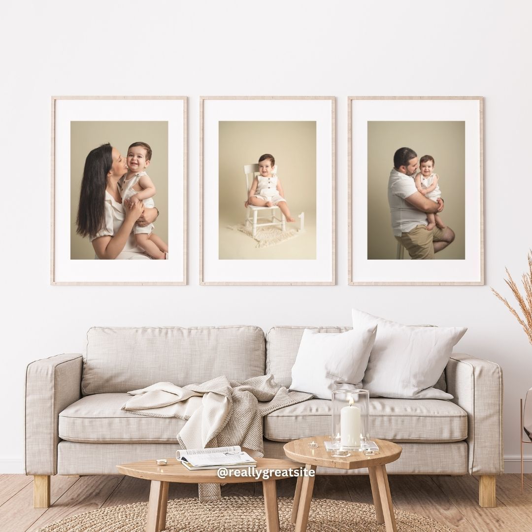 Three framed family portrait photos displayed above a beige sofa in a bright living room.
