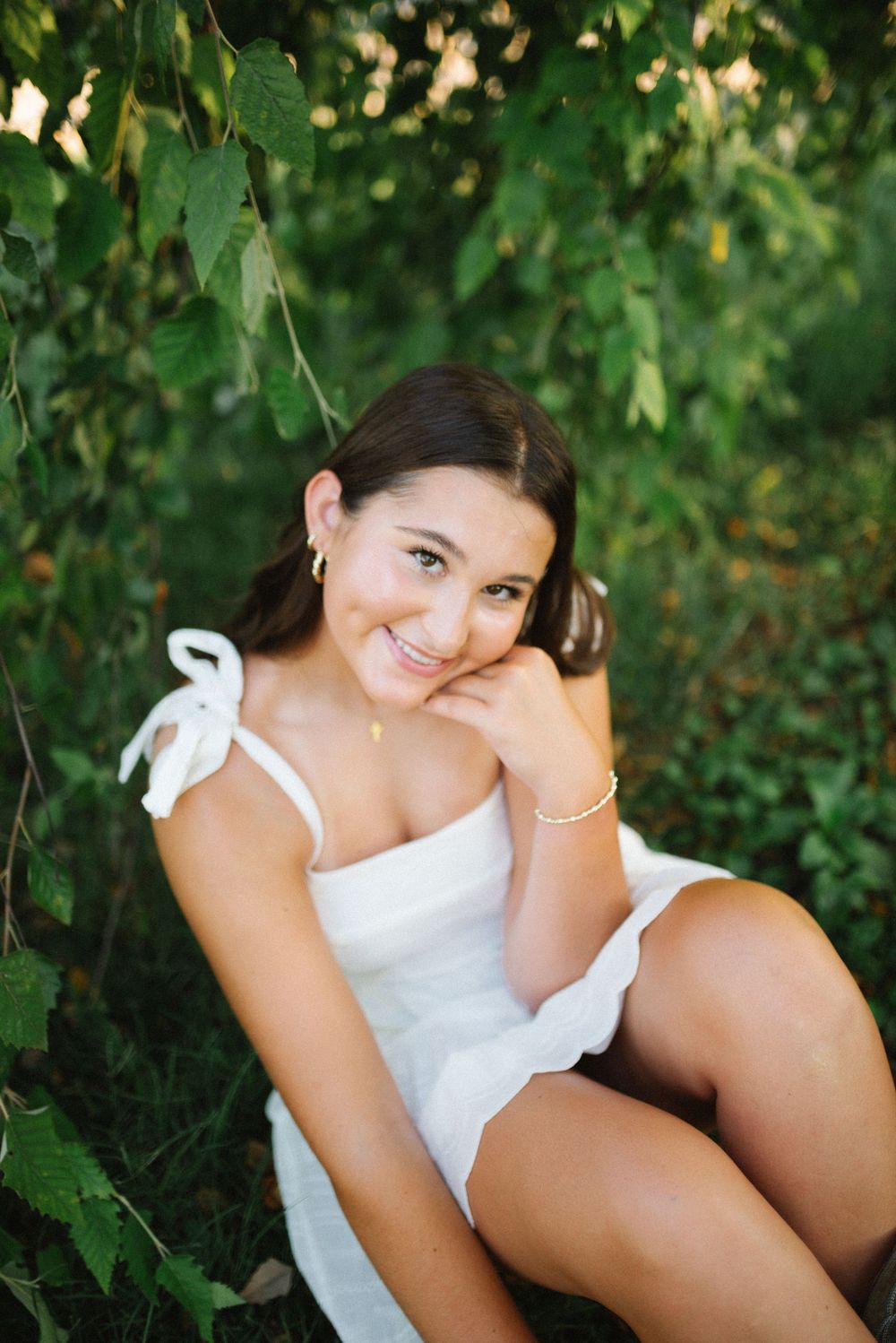 A casual summer portrait among green leaves and natural lighting.