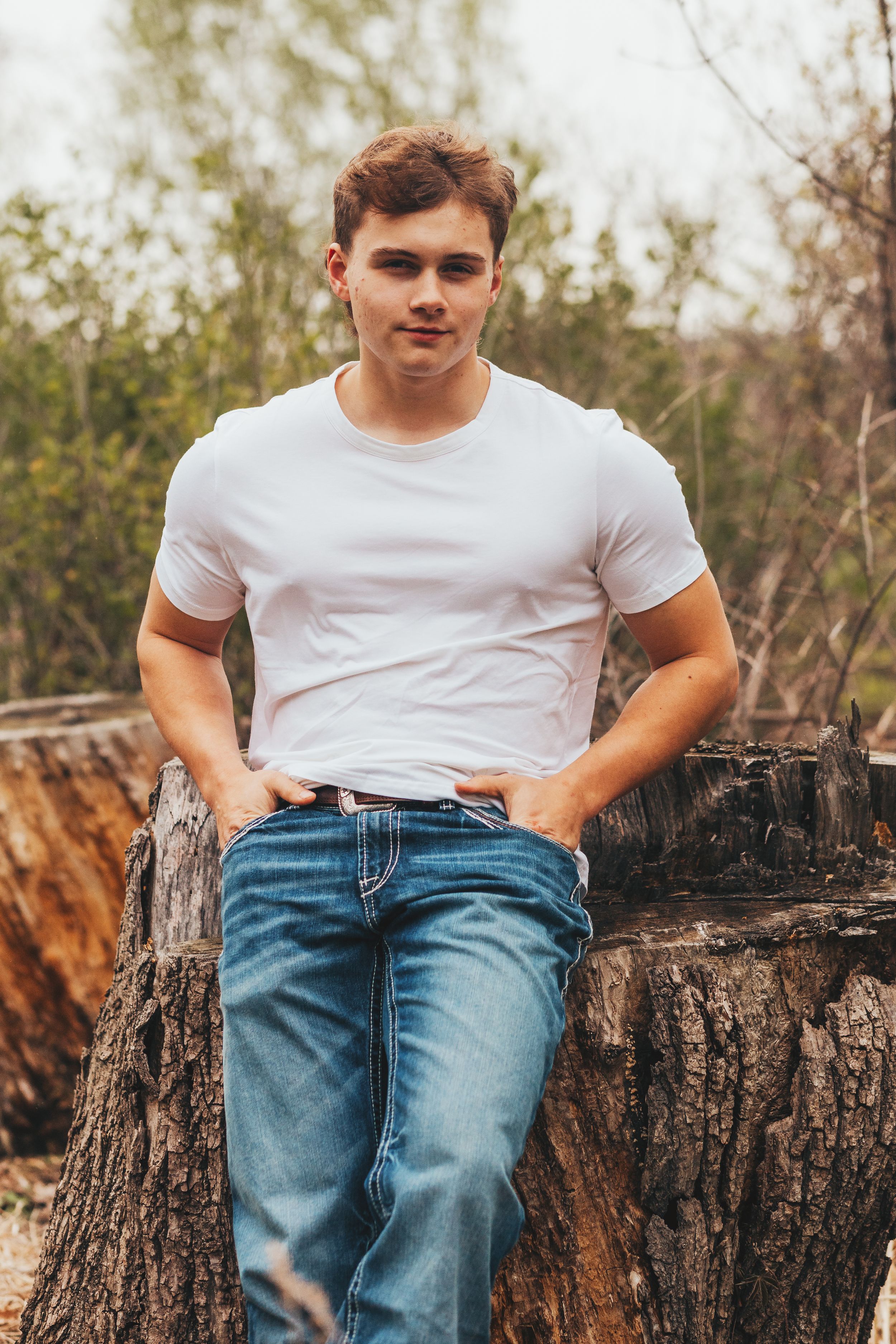 Boy leaning against log