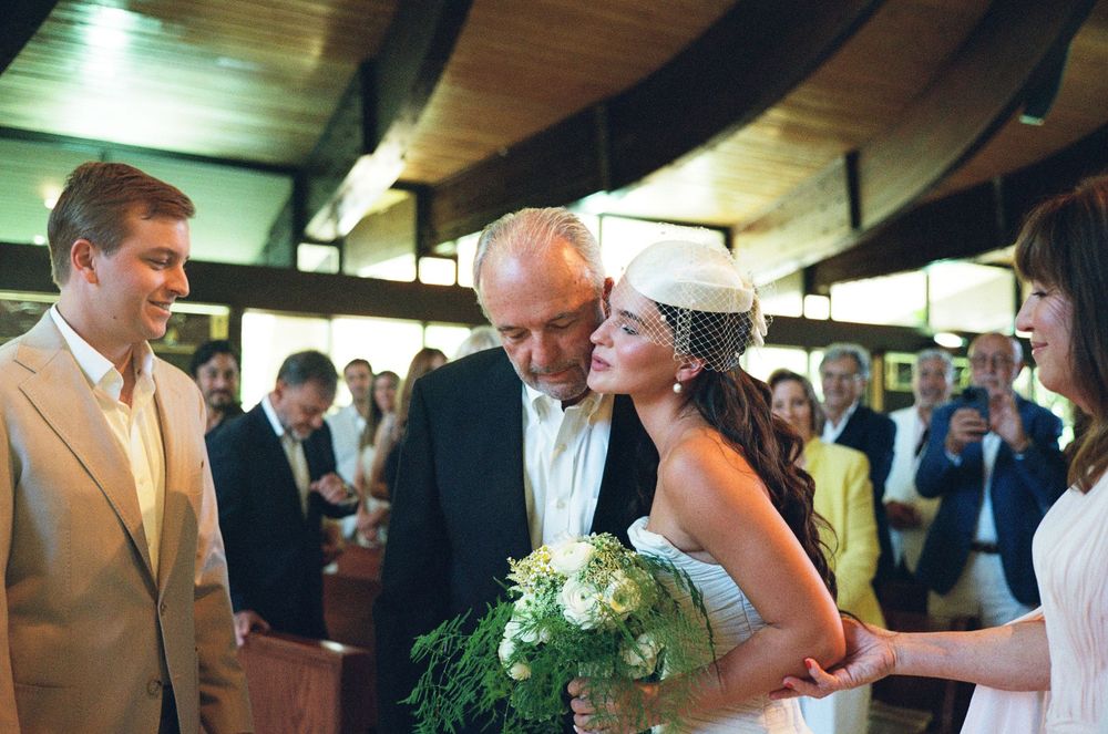People dancing and celebrating at what appears to be a wedding reception or social gathering.