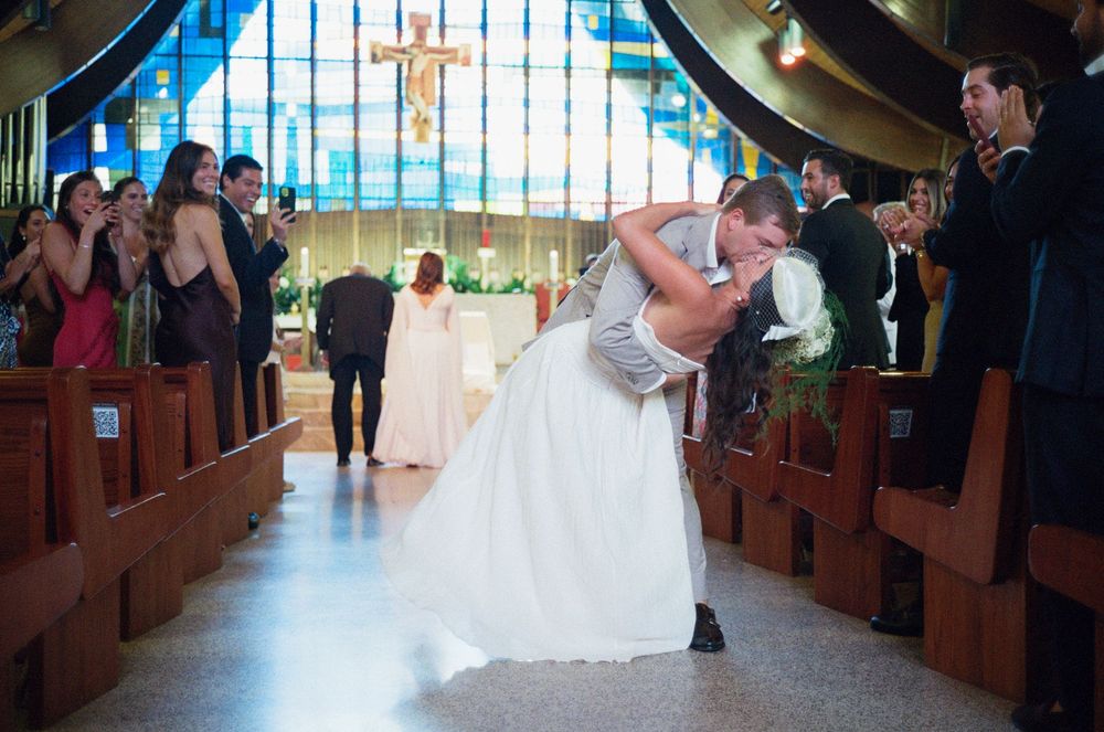 A couple shares a romantic dip while dancing together at their wedding reception in a church venue.