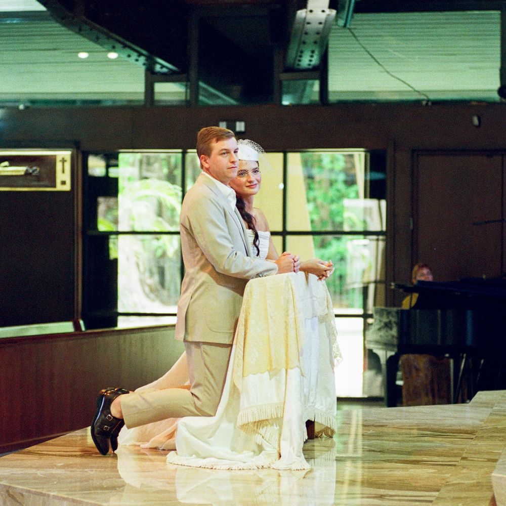A couple in formal attire dancing gracefully on a polished wooden floor during a wedding celebration.