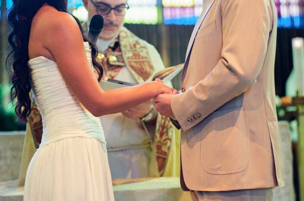 A couple in wedding attire shares a romantic dance moment on a wooden floor during their reception celebration.