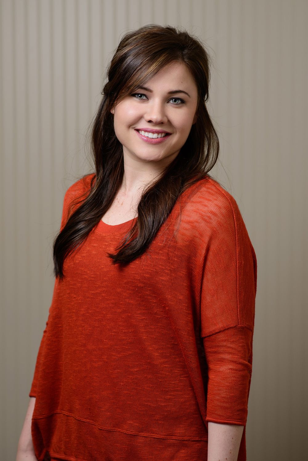 A series of studio portraits showing someone wearing a casual red knit top against a neutral background.