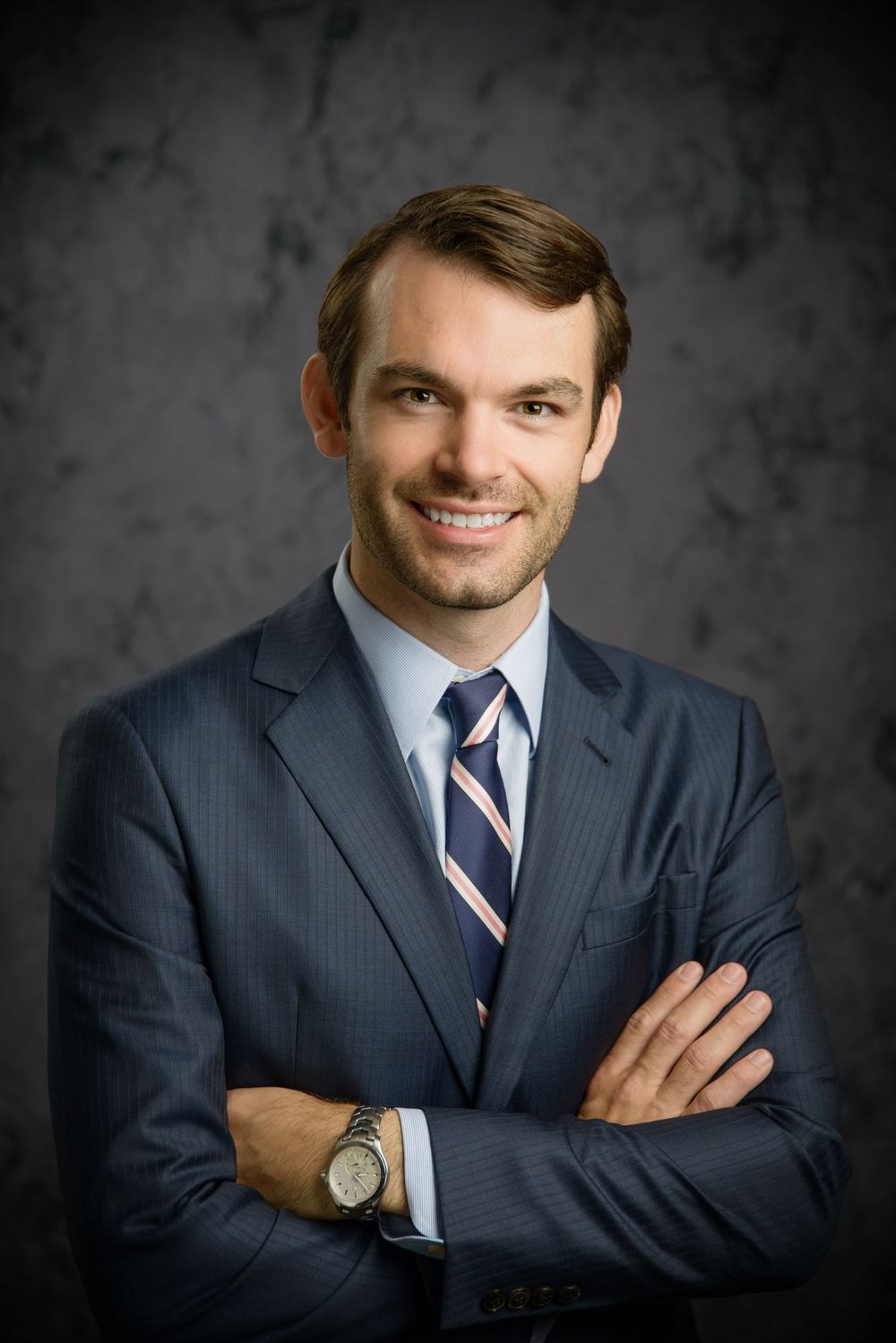 Professional headshot series of person in navy suit and striped tie against dark gray background.