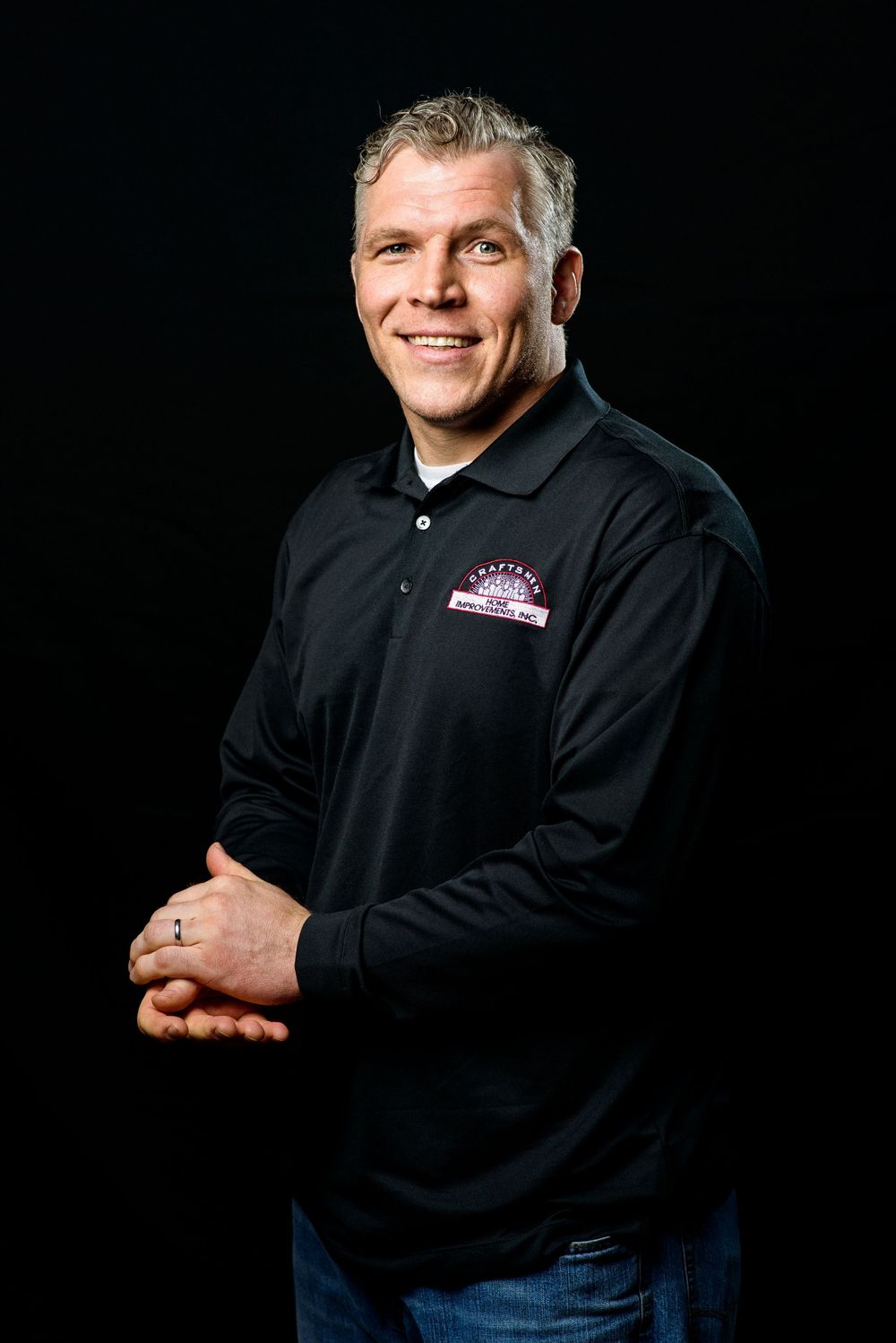 Professional studio portrait series showing person in black polo shirt and jeans against dark background in various poses.