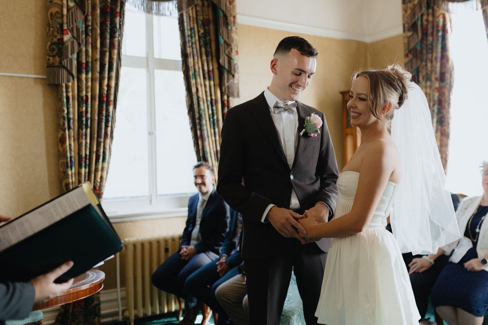 Intimate wedding ceremony moments captured in a series of black and white photos showing preparations in an elegant room.