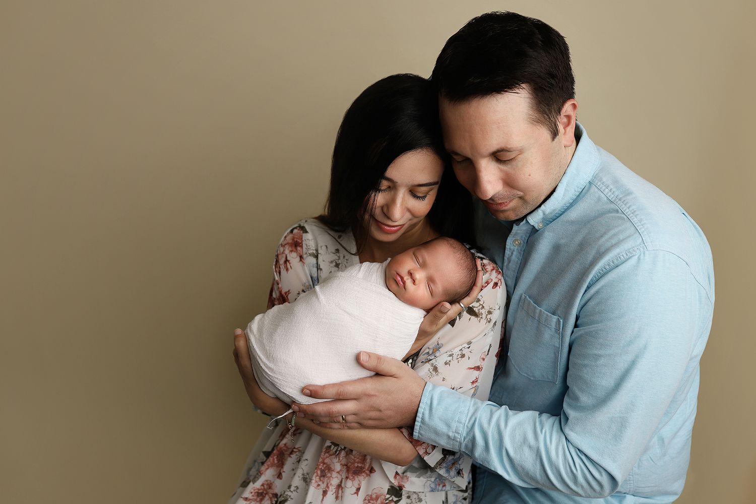 A series of tender moments between parent and newborn baby shown in multiple connected photos against a neutral backdrop. Utah studio.