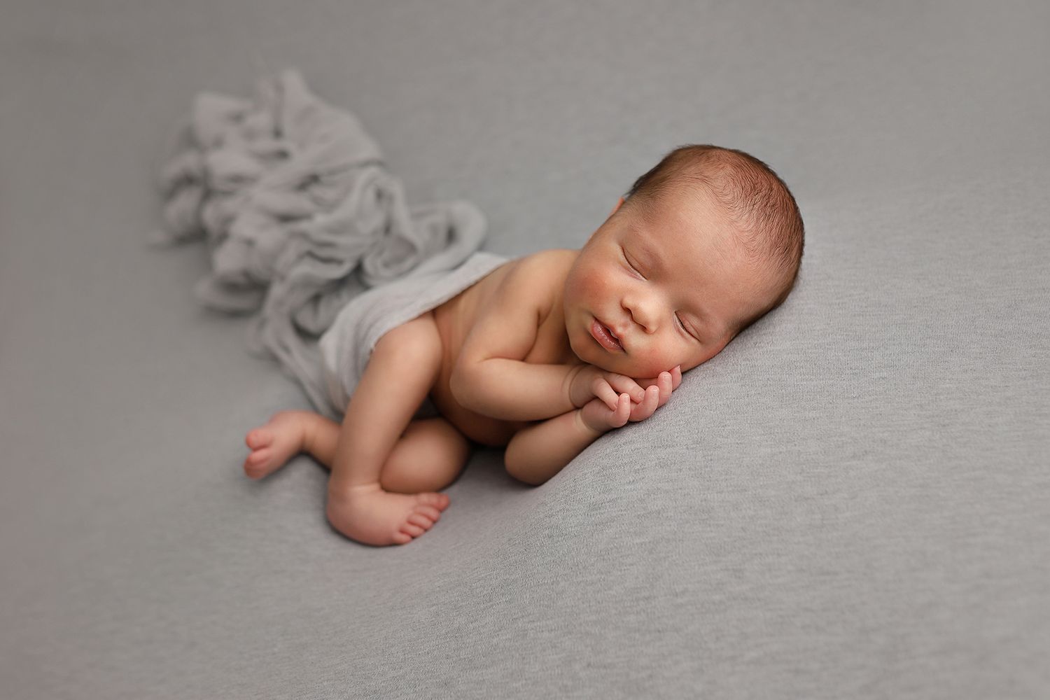 Sleeping newborn baby lying on soft gray blanket in artistic black and white photography. Utah County newborn photographer