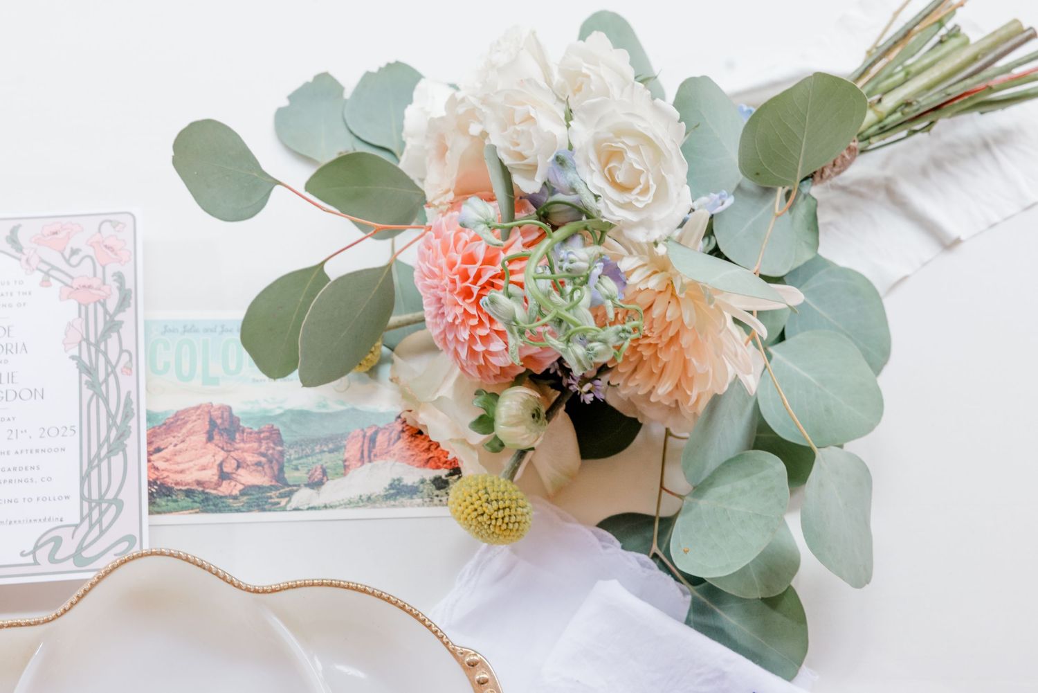 Delicate pink and white floral arrangements with eucalyptus leaves displayed in a romantic wedding styling layout.