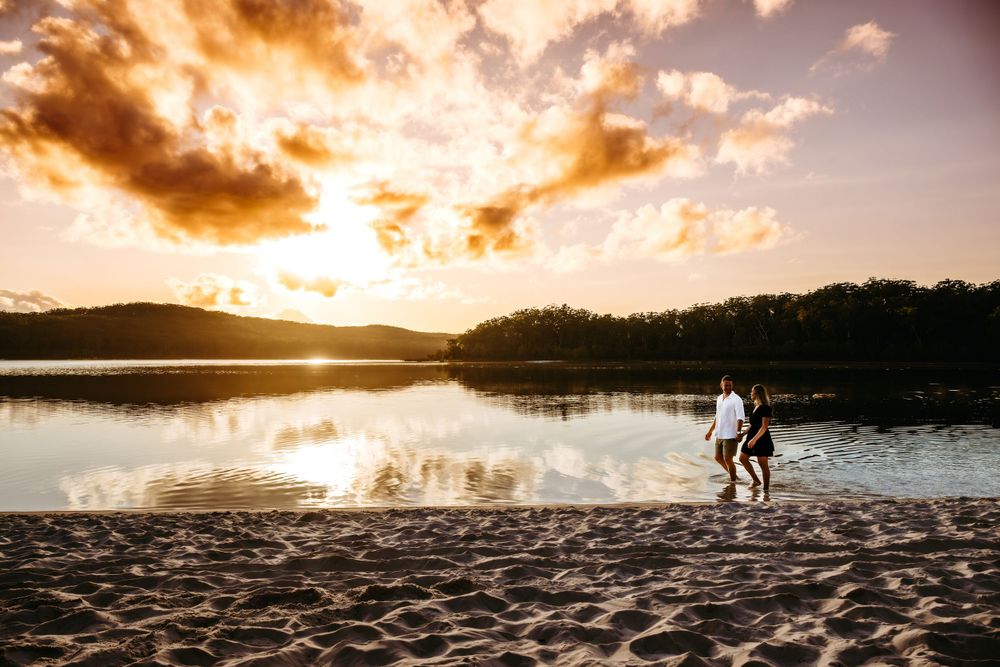 Silhouette of couple on beach during dramatic golden sunset.