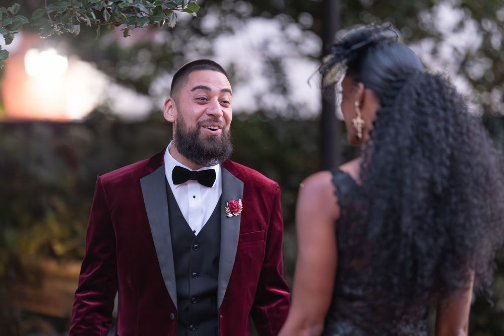 Couple in formal attire sharing a romantic moment during an evening outdoor event.