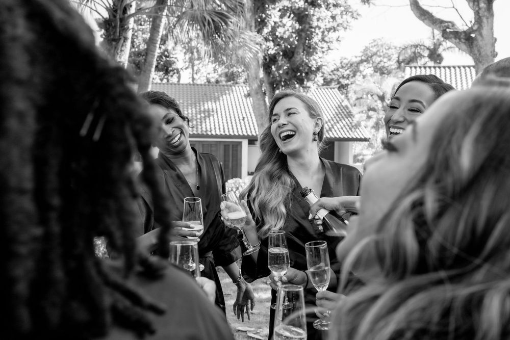 A black and white photo series shows people laughing and enjoying themselves at an outdoor gathering.