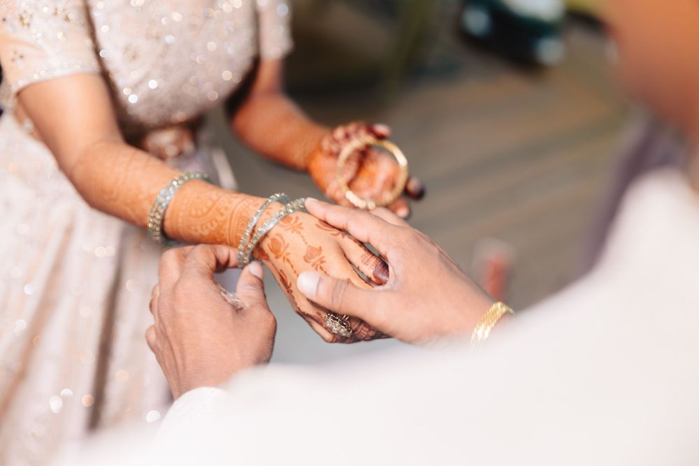 Close-up shots of hands with intricate henna designs and traditional Indian bridal jewelry.