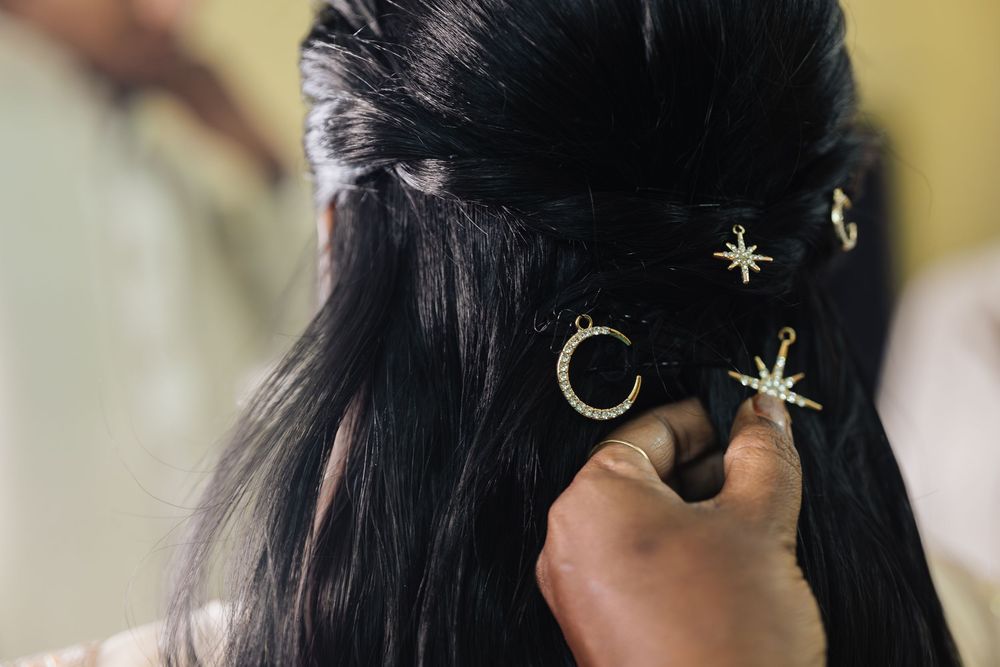 Close-up details of decorative hair accessories and jewelry against dark hair.