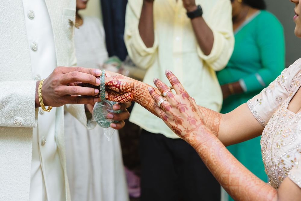 Close-up shots of hands with detailed mehndi designs during an Indian wedding ceremony.