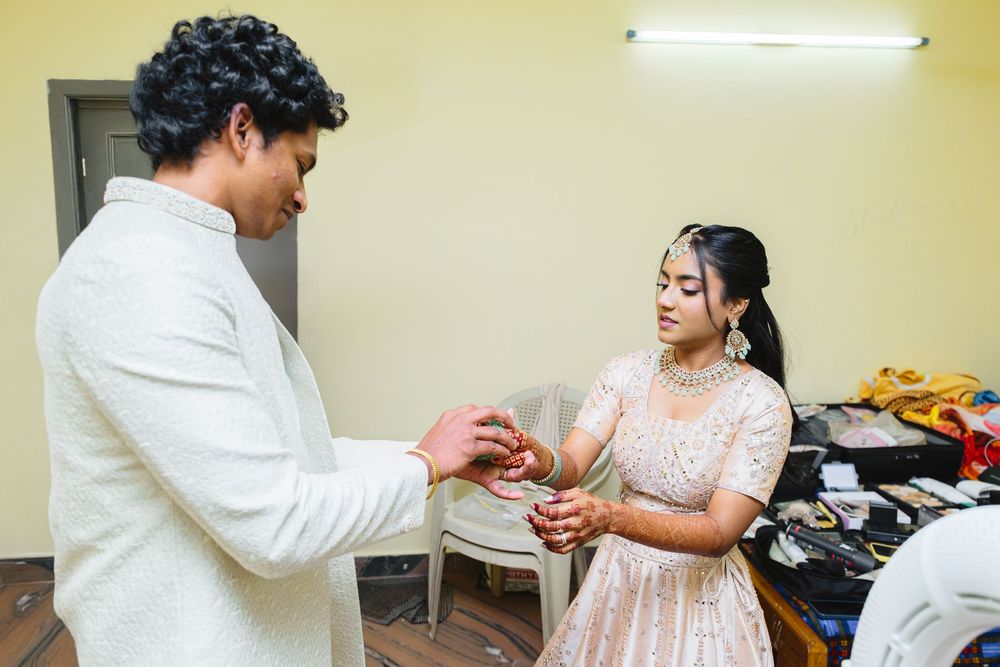 A couple shares a tender moment during what appears to be an Indian wedding ceremony.