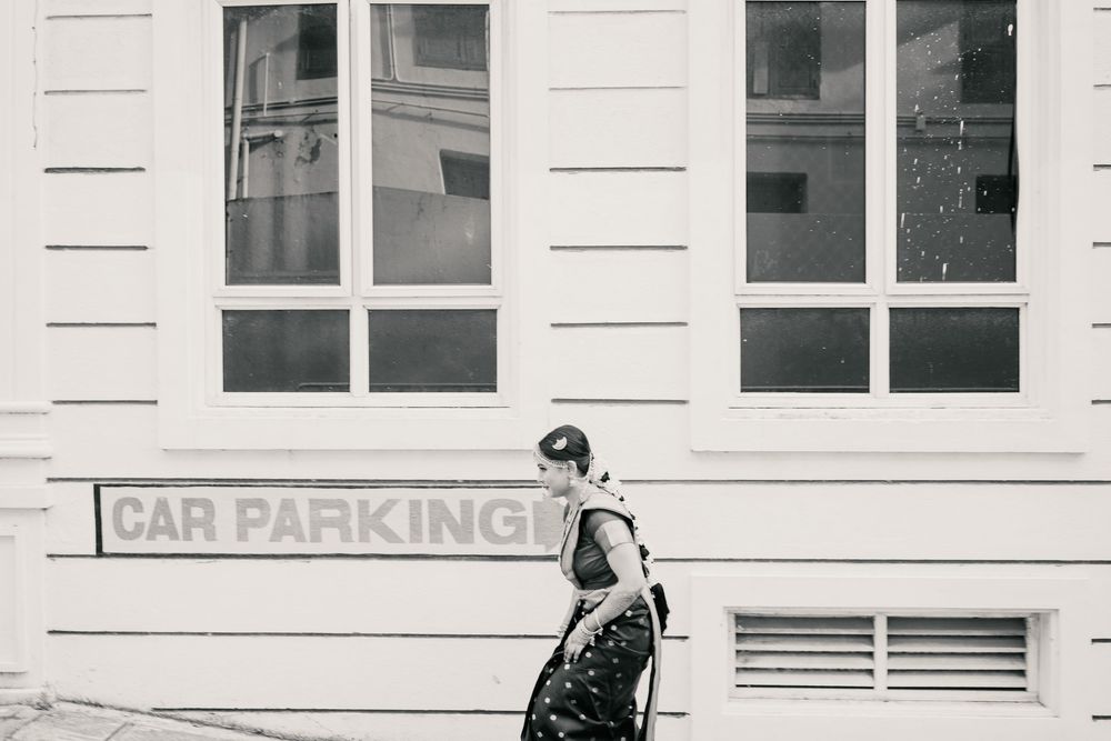 A couple in traditional South Asian wedding attire share an intimate moment in black and white photography.