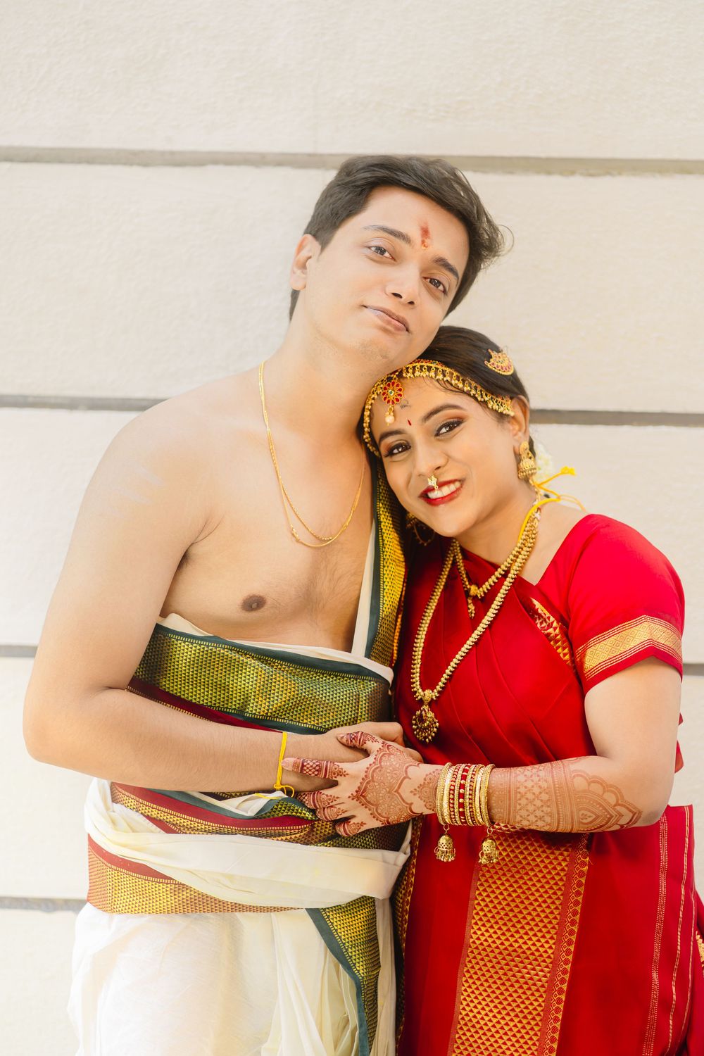 A couple in traditional Indian wedding attire pose together in a romantic photoshoot series.