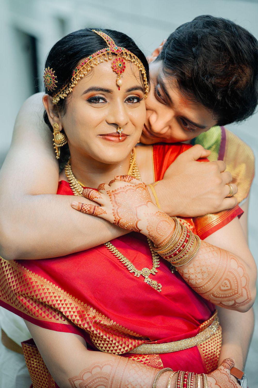 Romantic close-up shots of a couple in traditional Indian wedding attire with bride wearing red saree and gold jewelry.