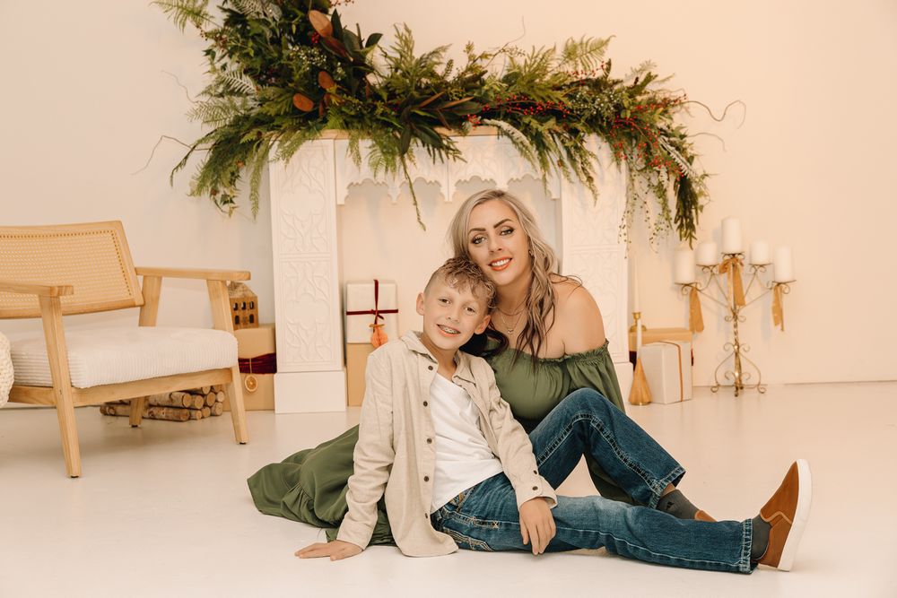 mother and son posing on the floor smiling for a Christmas pictures in Northern Colorado