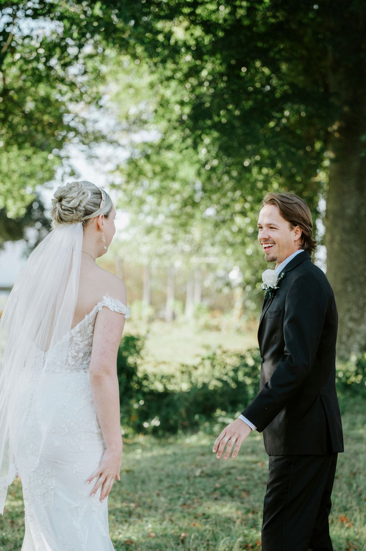 A candid series of photos shows a heartwarming first look moment between two people in wedding attire outdoors.