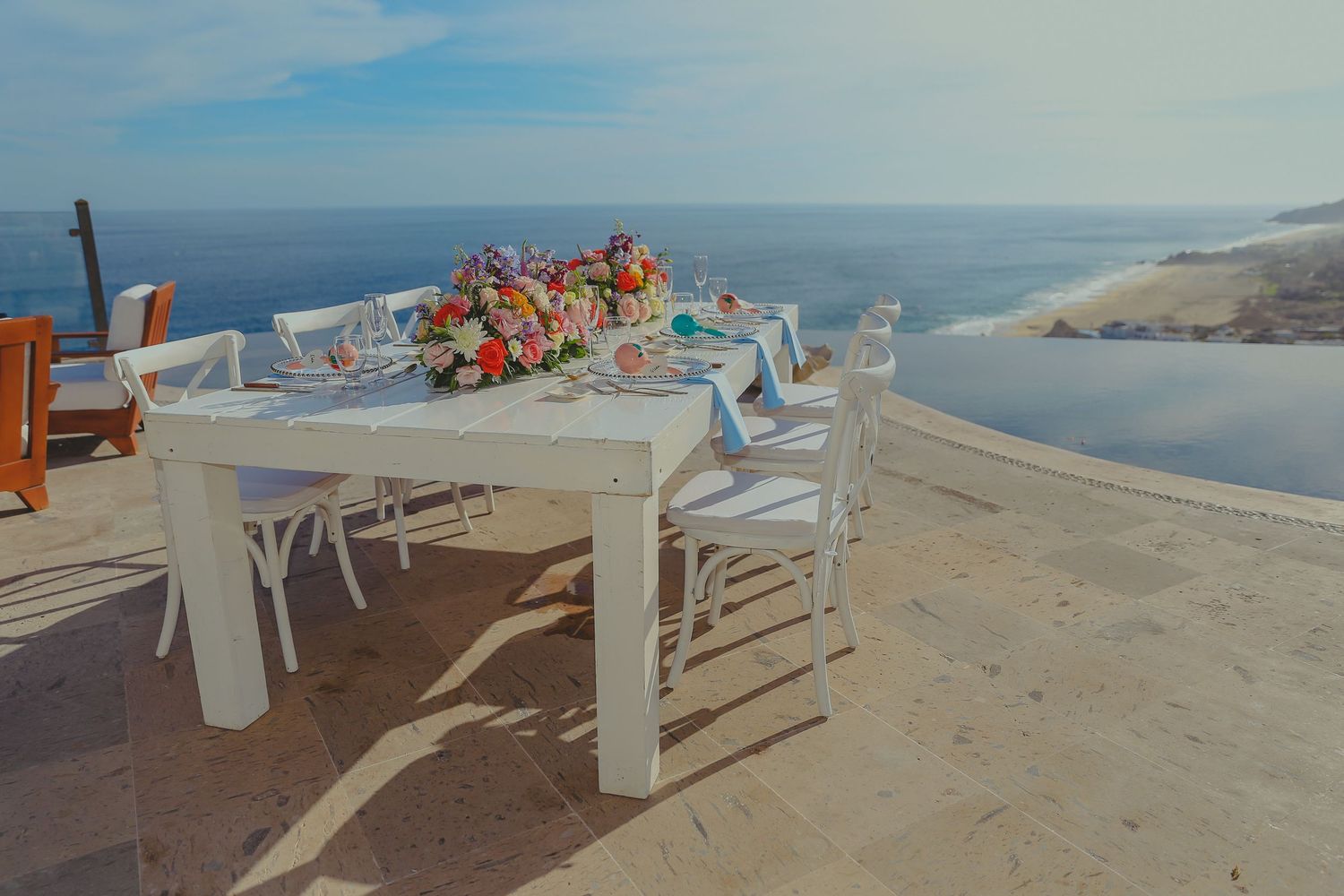Panoramic view of a coastal restaurant terrace with white chairs overlooking a Pedregal Los Cabos Wedding Photographer
