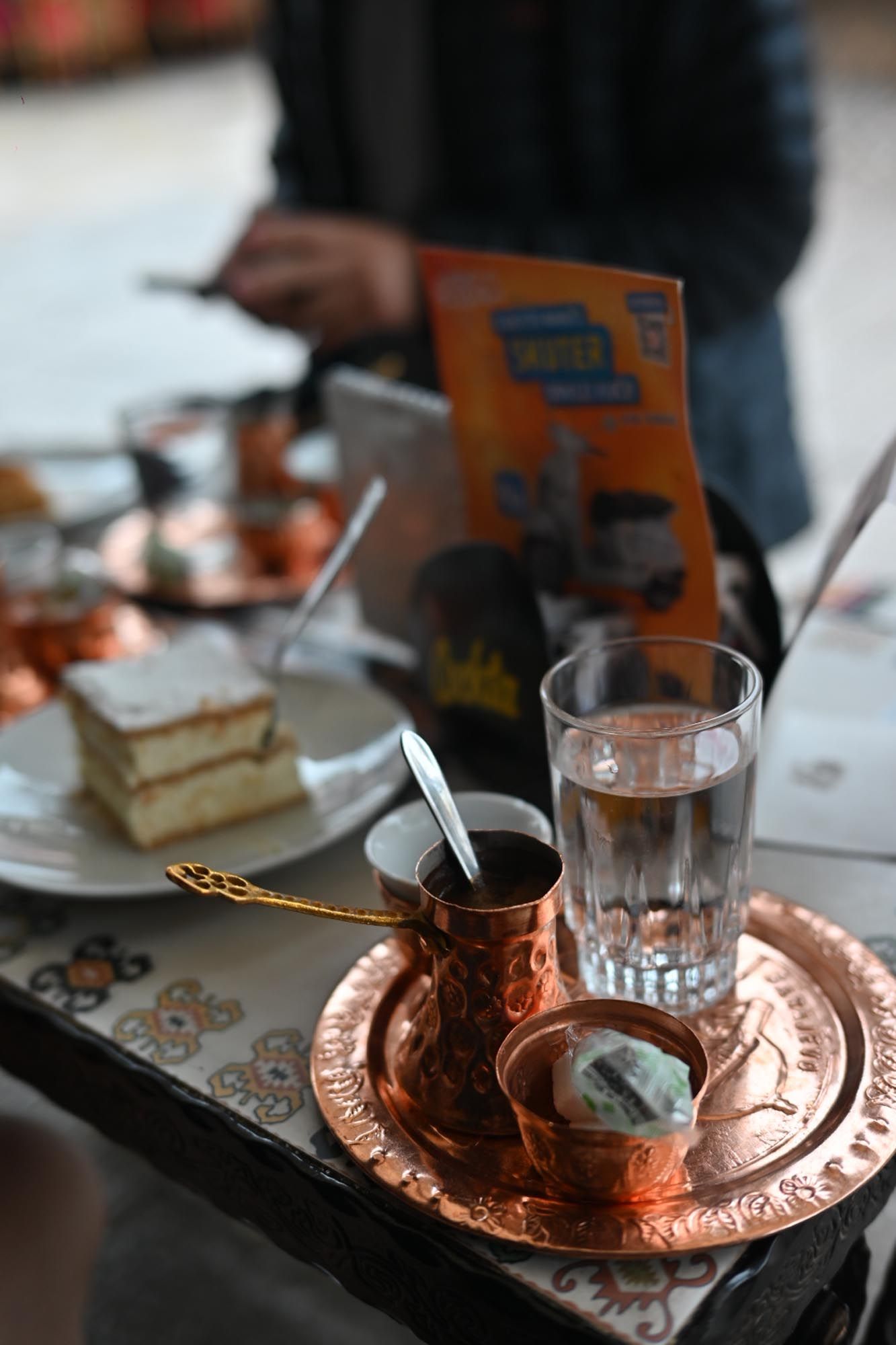 Traditional Turkish coffee service with copper cezve and ornate metal tray shown in progressive brewing stages.