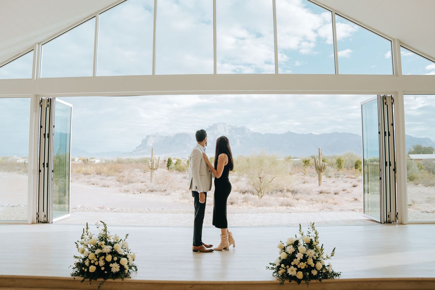 Bright chapel interior with floor-to-ceiling windows showing desert landscape.