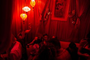 Red-lit lounge area with Chinese lanterns and gathered crowd.