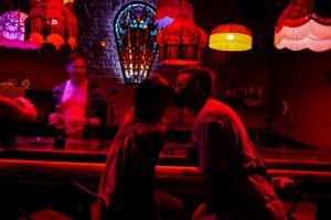 Atmospheric bar scene with colorful oriental-style lanterns casting red and orange glow.