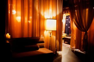 Warm-lit lounge interior with velvet curtains and ambient lamp lighting creating an intimate atmosphere.