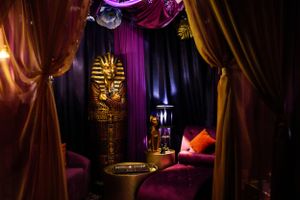Egyptian-themed lounge area with gold pharaoh decor and purple mood lighting.