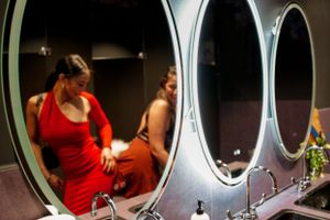 Row of illuminated vanity mirrors in a dressing room with modern lighting fixtures.