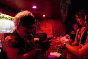 Dark nightclub scene with camera equipment and red ambient lighting.