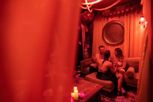 Cozy red-lit seating area with candles and vintage nautical-style decor.