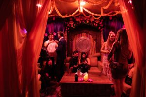 Dark venue interior with red drapes and mood lighting creating an intimate atmosphere.