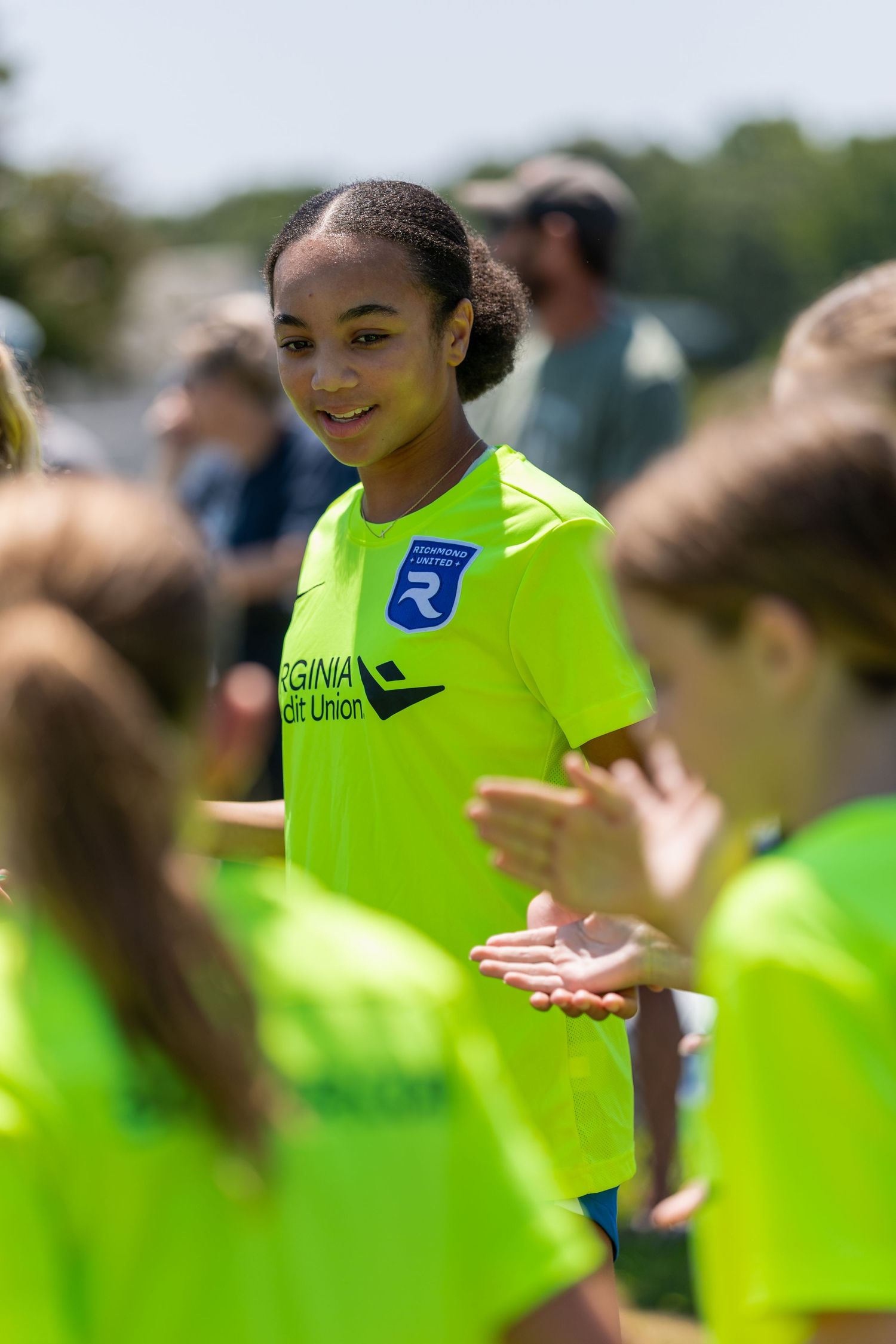 Youth athletes in bright yellow jerseys participate in outdoor training.